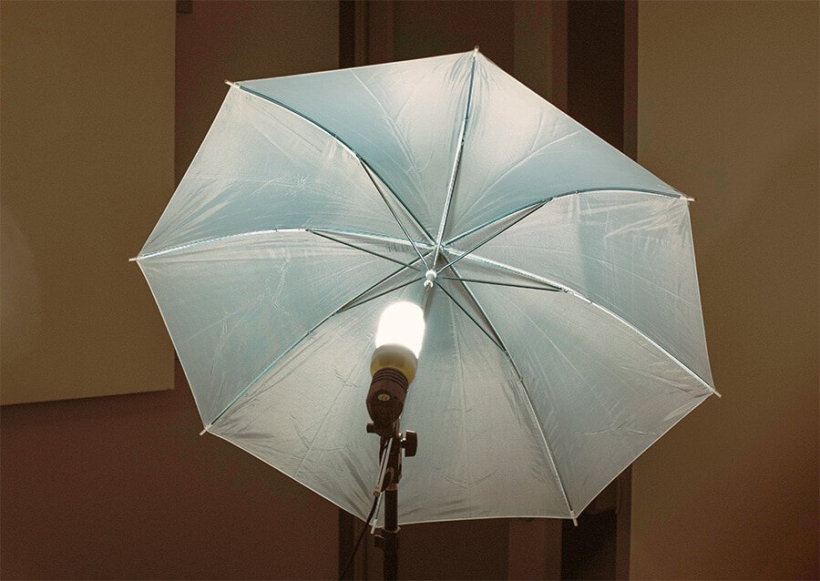 paraplylampa med spiral fluorescerande glödlampa monterad på ett ljusstativ. En av de fyra olika typerna av fotograferingsparaplyer.